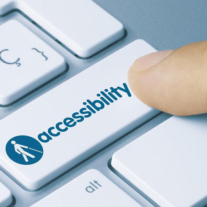 A finger pressing a decorative 'accessibility' key on a keyboard