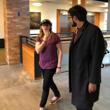 DJ conversing with a participant who is wearing a HoloLens while walking.