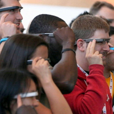 Several people in the crowd wearing a Google Glass.