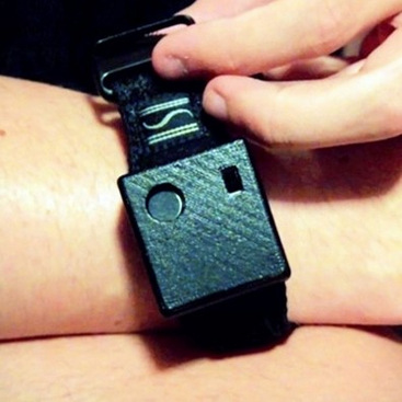 A user donning our black tactile sound awareness device on the wrist.